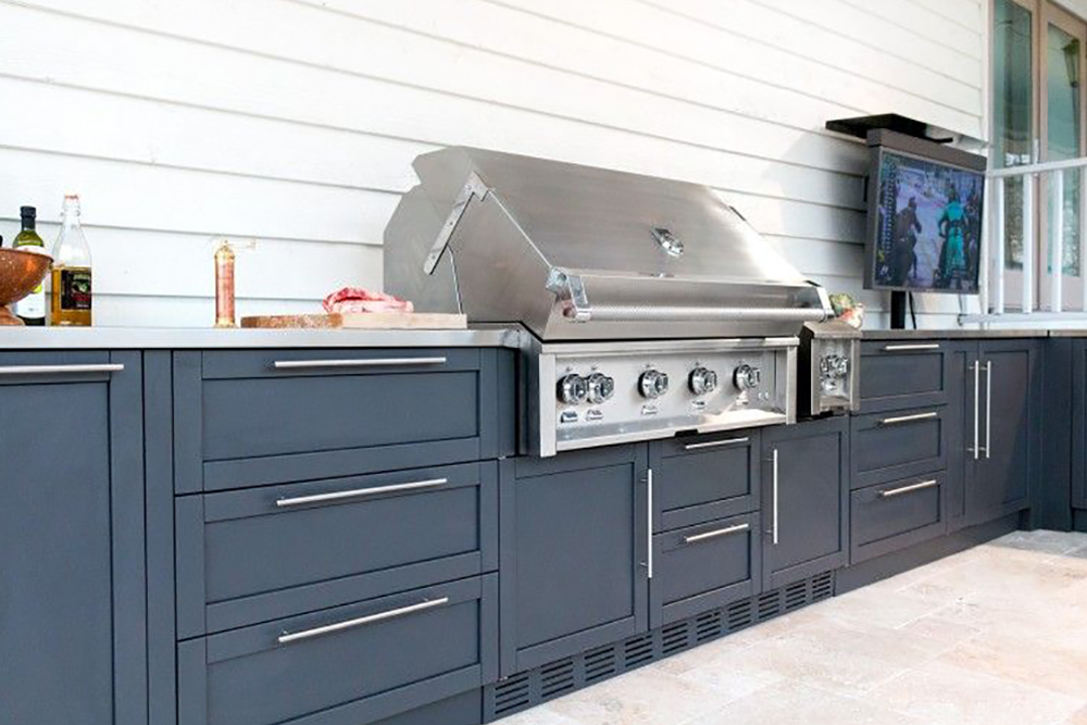 Dark grey outdoor kitchen with large built-in grill on a patio.