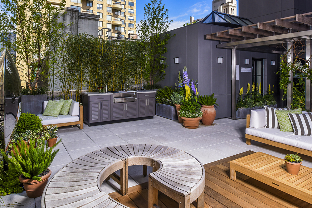 Outdoor patio with a gray kitchen station with stainless steel handles and appliances.