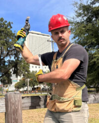 Josh Flinn, Installation team member, posing humorously outside with power tools.